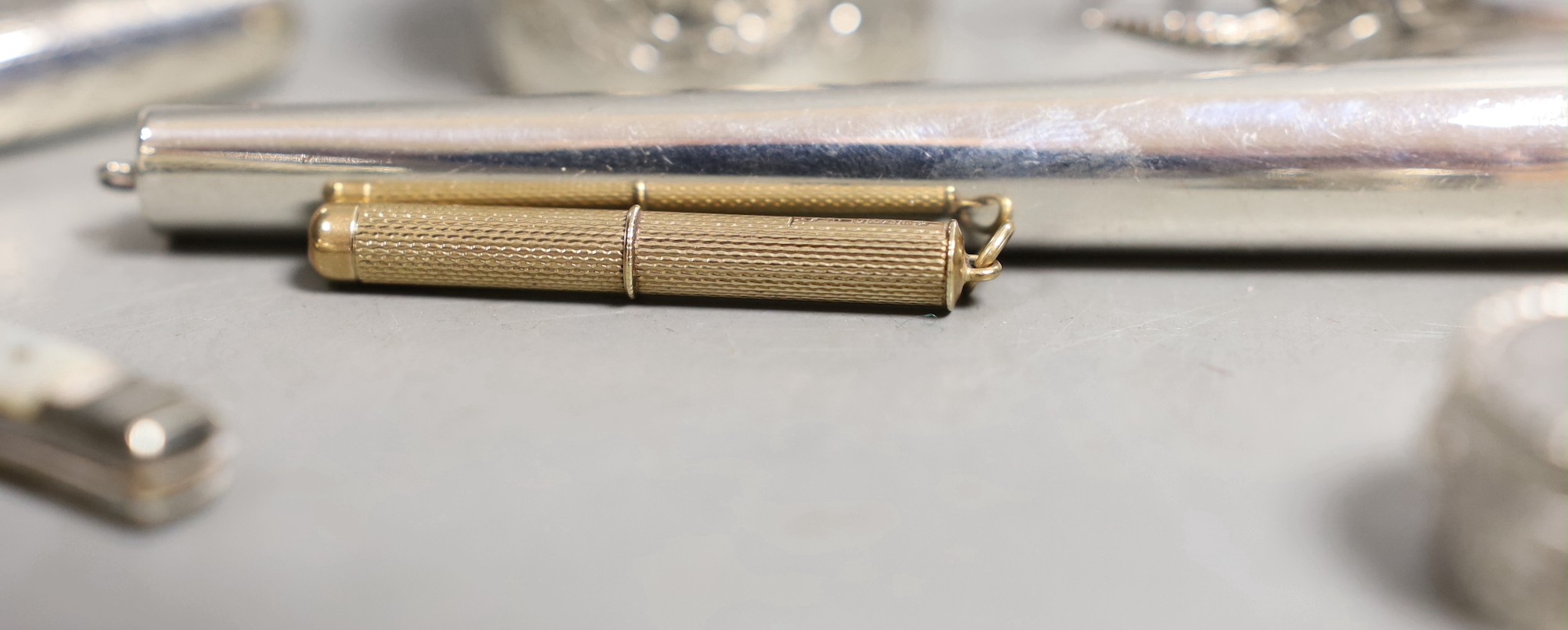 A 9ct gold cased propelling toothpick and nine other small silver or white metal items including pill box, handbag mirror, tongs, fruit knife etc.